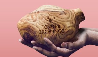 A pair of hands gently holds a wooden vessel engraved with a symbol and the words TENDER EXCHANGE against a pink gradient background.