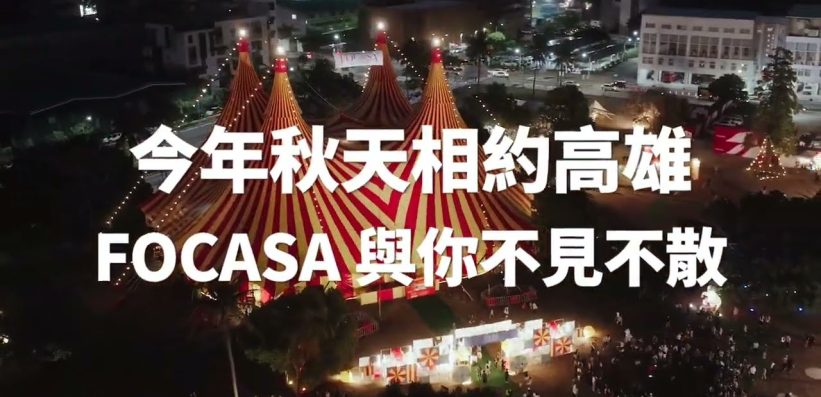 An aerial night view of a circus with red and yellow striped marquees, surrounded by lights and buildings, with bold Chinese and English text overlaid on the image.