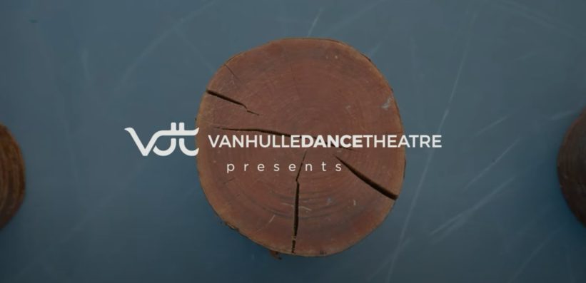 A logo for Van HuLle Dance Theatre appears over a round wooden log slice with visible cracks, set against a blue-grey background. The text reads VANHULLEDANCETHEATRE presents.