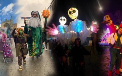 People in festive costumes, including tall figures with beards and glowing skeletons, pose outdoors during a parade or celebration. The setting transitions from day to night, capturing vibrant and joyful scenes.